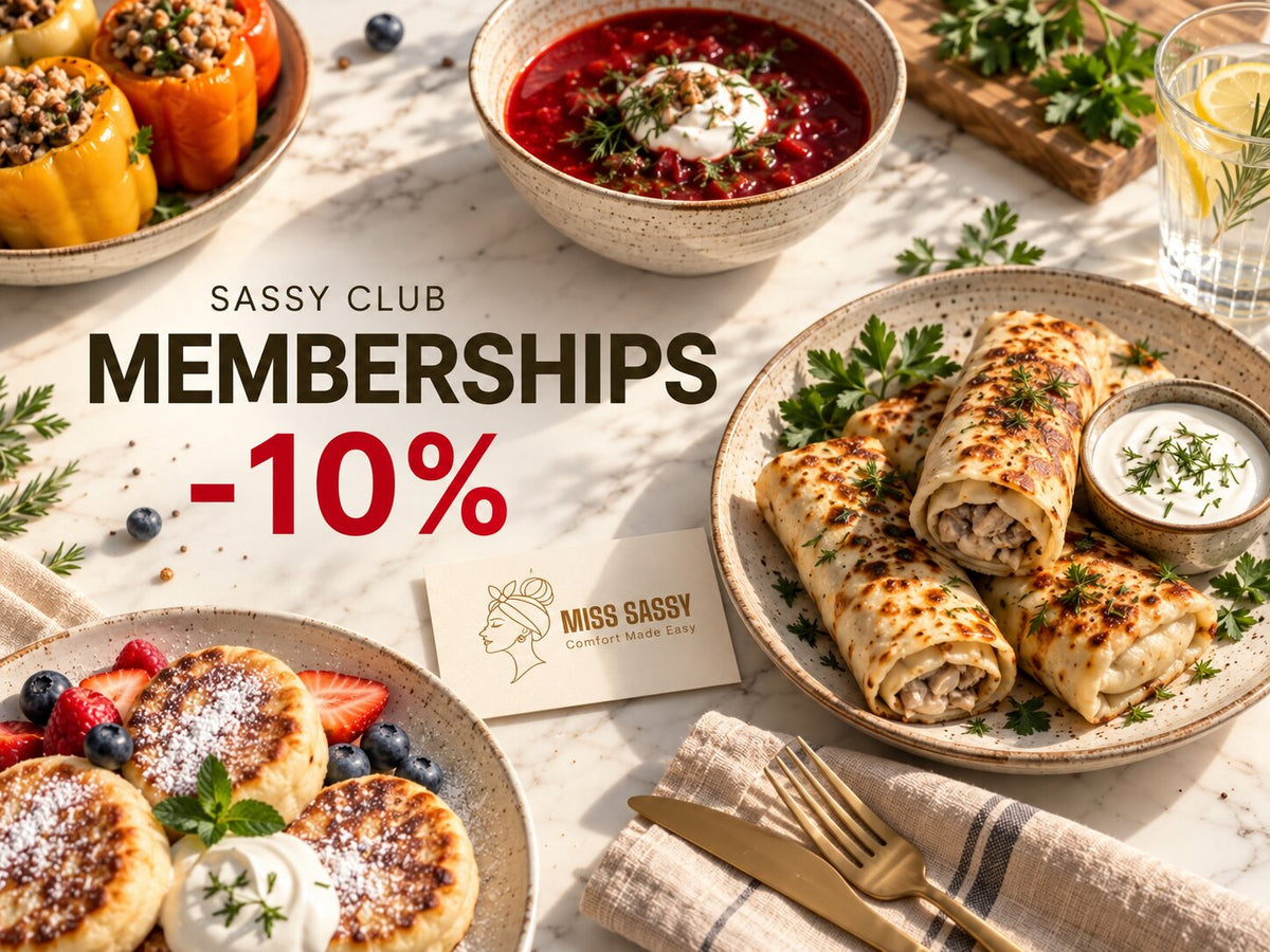A styled food spread on a light marble table with plates of stuffed peppers, a bowl of red soup with sour cream, pancakes with fruit and whipped cream, and chicken wrap rolls with a side of white sauce. Large overlaid text reads 'Sassy Club Memberships -10%' and a small card says 'Miss Sassy Gourmet Meals.